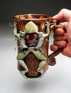 a hand holding a coffee mug with an image on it