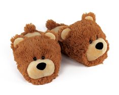 a brown teddy bear slipper is laying on the floor with it's eyes closed