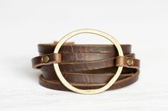 a brown leather bracelet with a gold circle on it