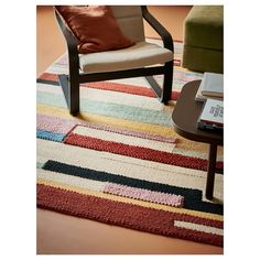 a chair and table in a room with rugs on the floor next to each other