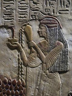 an egyptian relief depicting the god horus with his head bowed down and holding a staff