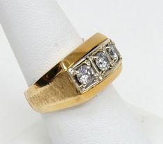 a gold ring with three diamonds on it