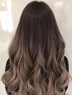 the back of a woman's head with long, wavy hair in grey tones