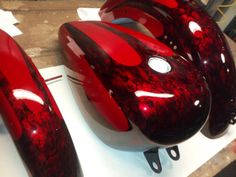 three red and black helmets sitting on top of a table next to eachother