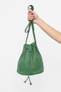 The Drawstring Bucket Bag is a classic that combines style and function. You’ll find that this spacious bag fits easily into your daily wardrobe. This artisanal product is made of genuine leather. All scars are characteristics of the skin and not imperfections. We hope you enjoy this unique handmade object. | Drawstring Bucket Bag for Women in Ivy Versatile Leather Satchel With Dust Bag, Daily Leather Bucket Bag With Leather Lining, Leather Pouch With Leather Handles, Green Leather Bucket Bag With Detachable Strap, Green Leather Backpack With Detachable Strap For Everyday, Classic Bucket Bag With Dust Bag For On-the-go, Everyday Leather Bucket Pouch, Daily Use Bucket Pouch With Detachable Strap, Chic Everyday Bucket Pouch