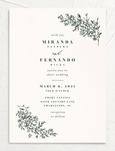 an elegant wedding card with black ink on white paper and greenery in the middle