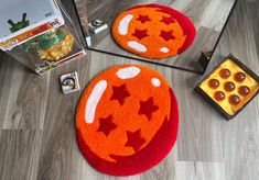 two halloween rugs on the floor next to a box of pop rocks and a toy