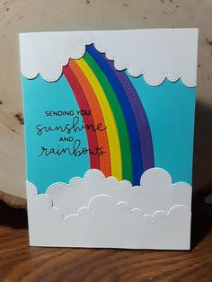 a greeting card with a rainbow and clouds on the front that says sending you sunshine and rainbows