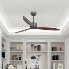 the ceiling fan is hanging in front of bookshelves and shelves with various items on them