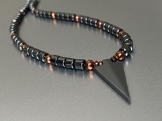 Masculine Magnetic Necklace with Arrowhead Pendant and Copper Finish Magnetic Beads, with Extra Strength Magnetic Clasp ... One of our most popular men's necklaces!  ~ Available in sizes 18 inches through 23 inches in length.  (21" shown in photo).  Beads are 6mm in size. // Clasps are Super Strength 8mm.  Hematite Arrowhead is  17x40mm in size. (Also available without Hematite Arrowhead). All of our Magnetic Jewelry features High Quality AAA Grade Magnetic Beads, Extra-strength Neodymium Magnetic Clasps and 90 Pound Strength Copolymer Beading Wire. USPS DOMESTIC SHIPPING Ships domestic USPS First Class within 3-5 Business days  // Please allow 10 Business days from date of purchase to delivery //  Please visit our shop for additional listings: http://www.Etsy.com/shop/StellaMagnetica Photo Beads, Magnetic Beads, Men's Necklaces, Magnetic Necklace, Super Strength, Magnetic Jewelry, Beading Wire, Copper Finish, Magnetic Clasp