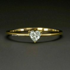 a gold ring with a heart shaped diamond