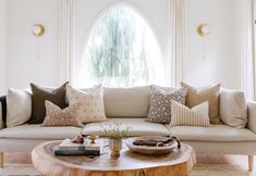 a living room filled with lots of furniture and pillows on top of a coffee table