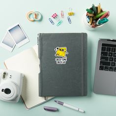 an open notebook sitting on top of a desk next to a camera and other office supplies