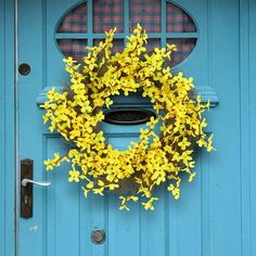 a blue door with a yellow wreath on it