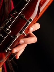 a close up of a person holding an instrument in one hand and playing the ukulele