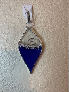 a blue and white glass ornament hanging on a wall