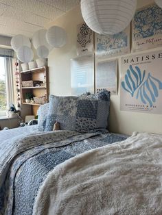 a bed room with a neatly made bed and some pictures on the wall above it