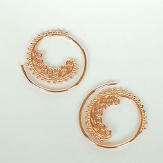 Indian style sterling silver spiral ear hoops. These are dipped in rose gold. Dimensions: 25 mm x 26 mm Price listed is for a pair. These earrings are made of 925 hypoallergenic sterling silver and rose gold All my pieces are sent in a gift box. I can include a personal message from you if needed. You are welcome to contact me at... bhavnakwintra1956@gmail.com More hoops: https://www.etsy.com/your/shops/TheSilverGame/tools/listings/section:26305414 More earrings: https://www.etsy.com/your/shops/ Rose Gold Wire Wrapped Hoop Earrings, Rose Gold Spiral Earrings With Ear Wire, Bohemian Rose Gold Jewelry With Ear Wire, Delicate Rose Gold Pierced Hoop Earrings, Rose Gold Bohemian Jewelry For Festivals, Bohemian Style Rose Gold Jewelry For Festivals, Handmade Small Hoop Rose Gold Earrings, Handmade Dainty Rose Gold Hoop Earrings, Rose Gold Sterling Silver Cartilage Earrings With Ear Wire