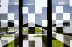 an image of the outside of a window with squares on it and grass in the foreground