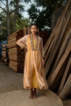 This stunning ensemble features a long-sleeve yellow gown paired with a matching jacket adorned with exquisite embroidery on the collar and sleeves. Perfect for Indian weddings or any special occasion, this readymade outfit offers versatility--you can wear the gown and jacket together for a coordinated look or opt for either piece alone to suit your style. Elegant and eye-catching, it's sure to make a statement at any party or event. Fabric - Orgenza, Georgette Satin Sleeve - Long Sleeves Work - Embroidered Designer Maxi Dress, Designer Resham Embroidery Front Open Dress, Wedding Dresses With Resham Embroidery And Front Open, Floor-length Embroidered Dress For Designer Wear, Long Embellished Designer Dresses, Spring Floor-length Dress With Zari Work, Hand Embellished Maxi Gown, Party Dress With Sheer Dupatta And Front Open, Elegant Front Open Designer Dresses