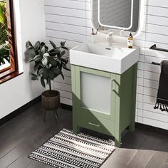 a white sink sitting under a bathroom mirror next to a green cabinet and counter top