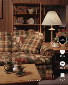 a living room filled with furniture and a lamp on top of a wooden table in front of a book shelf