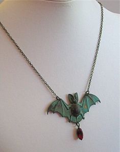 "Vampire Bat Necklace - Siam Faceted Crystal Glass Jewel in Antiqued Brass Setting dangles from a Verdigris Patina Brass Bat. The jewel looks like a droplet of blood. Bat measures just under 2.75\" wide x just over 1.25\" tall (excluding jewel) 24\" Brass Chain This is a stock photo. Each piece is unique. The verdigris will vary from the one pictured. For other bat designs: https://www.etsy.com/shop/mcstoneworks?ref=l2-shopheader-name&search_query=bat Be sure to check out my Patina Collectio Vampire Style Necklace For Halloween, Handmade Vampire Necklaces For Halloween, Vampire Style Halloween Necklace For Jewelry Making, Handmade Vampire Jewelry For Halloween, Gothic Dangle Necklaces For Halloween, Collectible Vampire Jewelry For Halloween, Handmade Vampire Jewelry For Cosplay, Handmade Vampire Style Jewelry For Cosplay, Vintage Costume Necklaces For Halloween