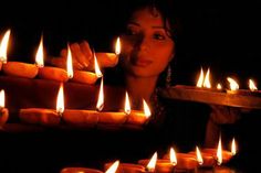 a woman holding a tray full of lit candles