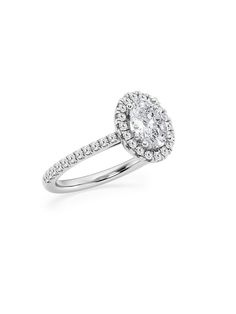 an oval shaped diamond ring with pave set diamonds on the shoulders and sides, in white gold