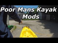 a man standing next to a yellow kayak on top of a parking lot with the words poor mans kayak mods