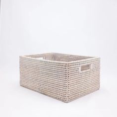 a wicker basket with handles on a white background