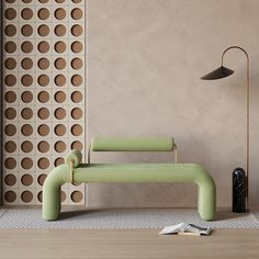 a green bench sitting next to a lamp on top of a wooden floor in front of a wall