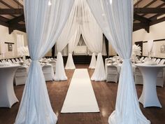 a room filled with tables covered in white drapes