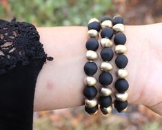 "PLEASE read ENTIRE listing BEFORE purchasing These gorgeous custom watch bands are the perfect arm candy for your Apple Watch! Each band is crafted with gorgeous matte black and distressed gold beading and hardware on a stretch band. Choose between petite or chunky beads and you're ready to rock your arm stack, watch in tow! MEASUREMENTS: *These bands fit 38mm and 40mm Apple Watch faces ONLY and are ONE SIZE to fit an average sized wrist. *I do NOT offer custom sizes, so please be sure that thi Black Beaded Bracelets For Gift, Gift Black Beaded Bracelets, Black Beaded Bracelet With Round Beads, Gold Jewelry With Black Band As Gift, Arm Stack, Beaded Watches, Stretch Band, Apple Watch Faces, Chunky Beads