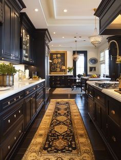 a large kitchen with black cabinets and an area rug on the floor in front of it