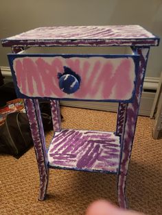 a pink and purple table with a hole in the middle on carpeted flooring