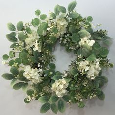 a wreath with white flowers and green leaves