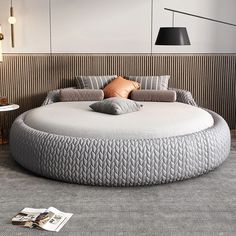 a large round bed sitting on top of a carpeted floor next to a lamp