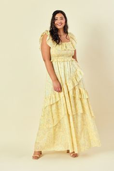 a woman in a yellow dress posing for the camera with her hands on her hips