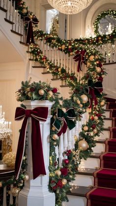 stairs decorated with christmas garland and ornaments for the holiday season, along with lights and chandeliers