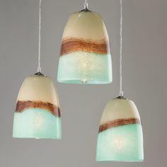 three hanging lights with different shades of green and brown on the bottom one is white, the other is light blue