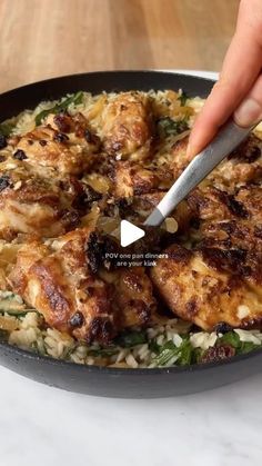 someone using a knife to cut up some food in a skillet on a table