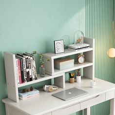 a laptop computer sitting on top of a white desk next to a shelf filled with books