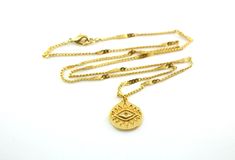 A rich golden eye has been crafted on a medallion and set on sturdy twinkling golden chains to create this gorgeous enchanting necklace, perfectly suited for layering. This open eye symbol is found across many cultures, bringing the bearer luck and protection. The 15x16mm 24k gold plated eye charm rests on 1.5x2mm 24k gold plated curb chains that have been flattened at even intervals to create a wavy starburst effect. This necklace is finished with a 24k gold plated lobster claw clasp. This neck Gold Chain Necklace With Evil Eye As Gift, Gold Chain Necklace With Evil Eye For Gift, Gold Medallion Necklace With Evil Eye, Evil Necklace, Crescent Moon Necklace Gold, Luck Necklace, Eye Of Providence, Star And Moon Necklace, Good Luck Necklace