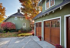 a green house with two garage doors on each side