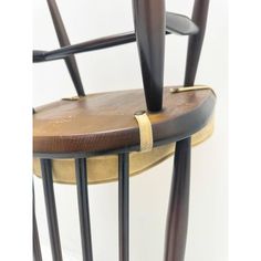 a wooden chair with black metal legs and a leather seat pad on the backrest