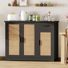 a black cabinet with wicker doors and shelves on the wall next to a wooden table