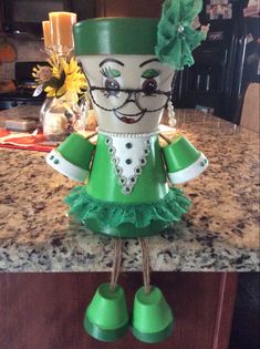 a green and white doll sitting on top of a counter