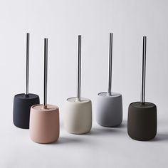 four different colored toothbrush holders with black, white, grey and pink ones on them