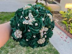 a bridal bouquet in the palm of someone's hand with flowers on it